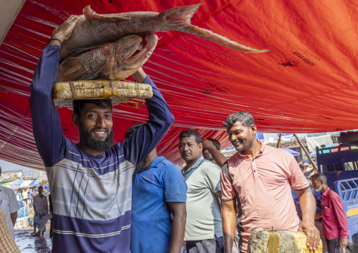 Bangladeshi man carrying big fishes on his head, Chittagong Division, Chittagong, Bangladesh
