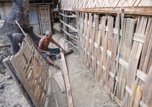 Marma ethnic group people man cutting bamboos to build a house, Chittagong Division, Rowangchhari, Bangladesh