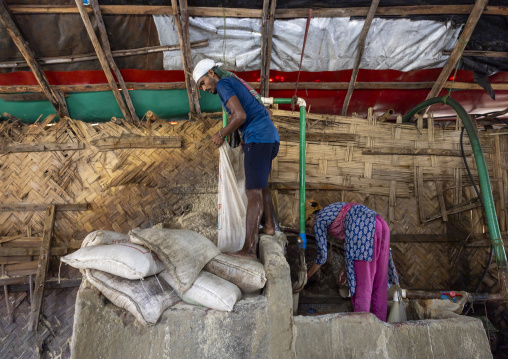 Bangladeshi workers packing salt in bags in a factory, Chittagong Division, Chittagong, Bangladesh