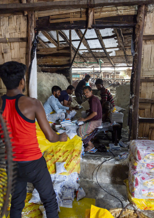 Bangladeshi men packing salt in plastic bags, Chittagong Division, Chittagong, Bangladesh