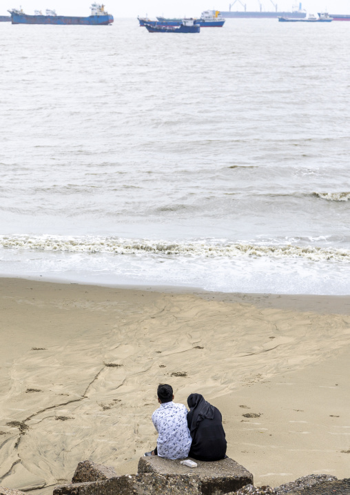 Couple on the beach looking at tanker ships, Chittagong Division, Chittagong, Bangladesh