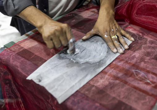 Bangladeshi worker putting some chalk to print a design on a fabric, Dhaka Division, Dhaka, Bangladesh
