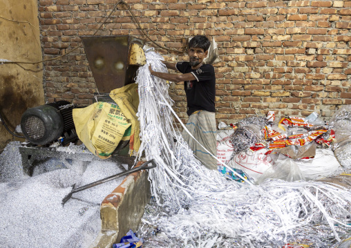 Bangladeshi man dismantling plastic bags for recycling, Dhaka Division, Dhaka, Bangladesh