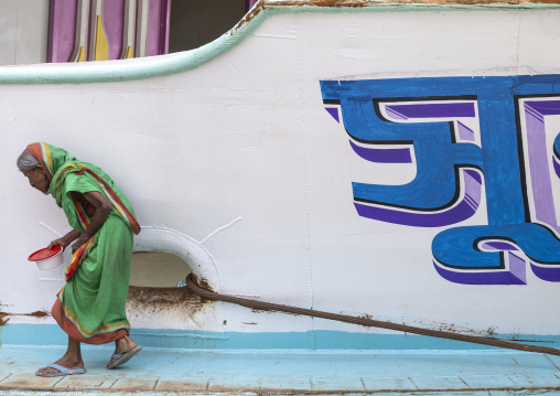 Old woman going inside an anchored ferry vessels at the dockyard, Dhaka Division, Dhaka, Bangladesh