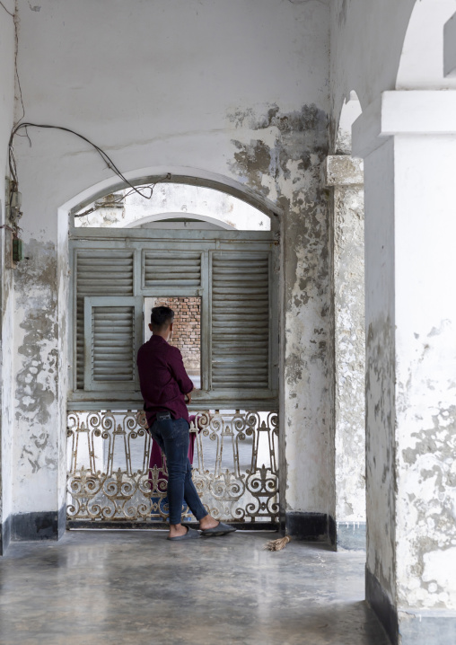 Bangladeshi man standing in front of a window in Baliati palace, Dhaka Division, Saturia, Bangladesh