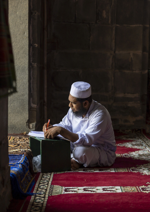 Bangladeshi imam writing inside Kusumba Mosque, Rajshahi Division, Kusumba, Bangladesh