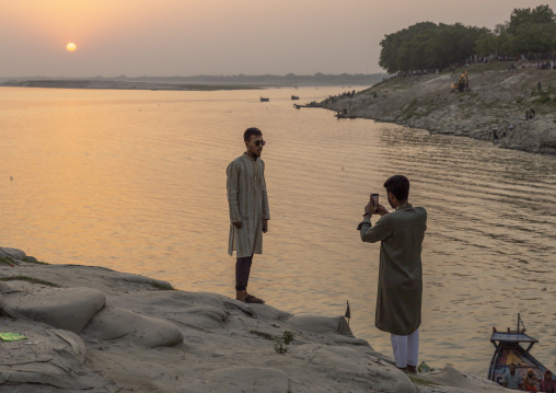 People taking picture on bags filled with sand to prevent from erosion, Rajshahi Division, Rajshahi, Bangladesh