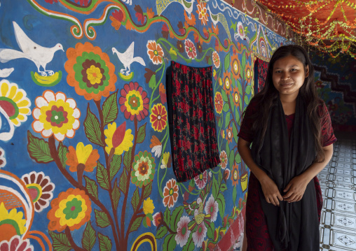Bangladeshi woman in front of a traditional wall painting in a house, Rajshahi Division, Tikoil, Bangladesh