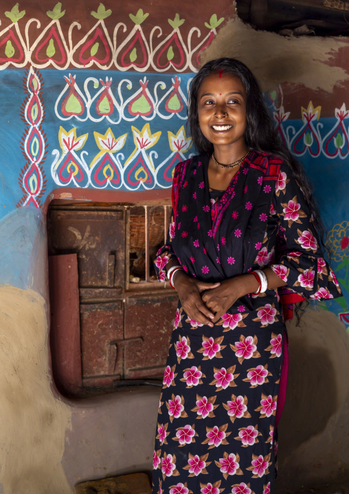 Bangladeshi teenage girl in front of a traditional wall painting in a house, Rajshahi Division, Tikoil, Bangladesh