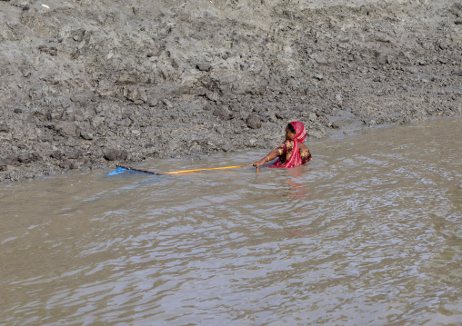 Bangladeshi woman fishing shrimps in the river, Khulna Division, Mongla, Bangladesh