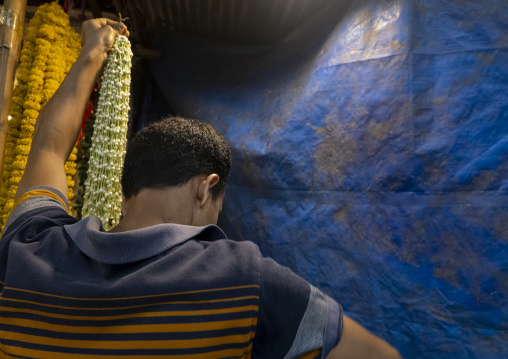 Bangladeshi man selling garland flowers at flower market, Dhaka Division, Dhaka, Bangladesh