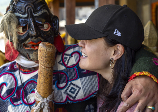Atsara showing a wooden phallus to a tourist at the Ura Yakchoe festival, Bumthang, Ura, Bhutan