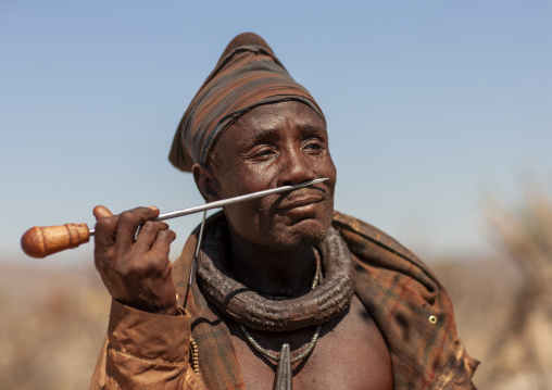 MuHimba man snuffing tobacco, Cunene province, Oncocua, Angola