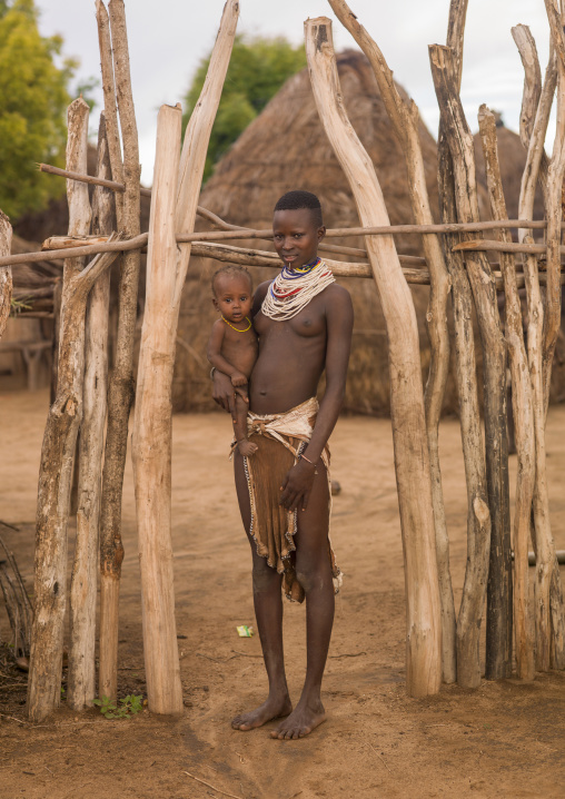 Portrait of a Karo tribe mother and kid at the entrance of their hut, Korcho, Omo valley, Ethiopia