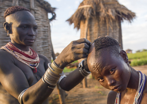 Karo tribe woman receiving a haircut, Korcho, Omo valley, Ethiopia