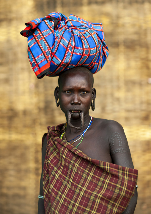 Mursi tribe woman with extended inferior lip and ear lobes, Ari zone, Jinka, Ethiopia
