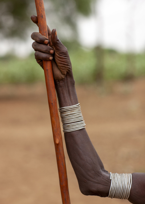 Dassanech woman arm and wooden stick, Omo valley, Omorate, Ethiopia
