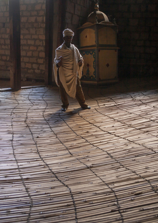 Priest inside Yemrehana krestos rock church, Amhara Region, Lalibela, Ethiopia