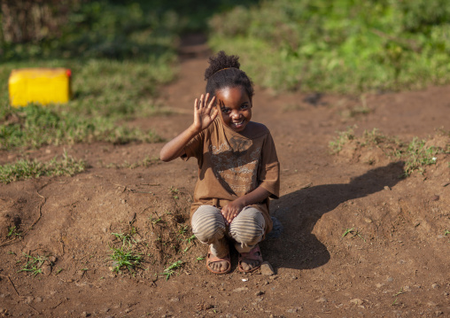 Young girl waving hand, Bench Sheko, Bebeka, Ethiopia
