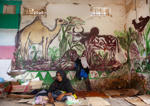 A woman on the floor in front of a livestock fresco, Maroodi Jeh region, Hargeisa, Somaliland