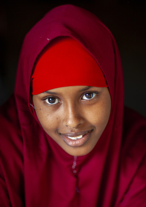 Portrait of a smiling young woman in red veil, Sahil region, Berbera, Somaliland