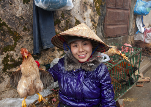 Woman with a conical hat showing a chicken, Lao Cai province, Sapa, Vietnam