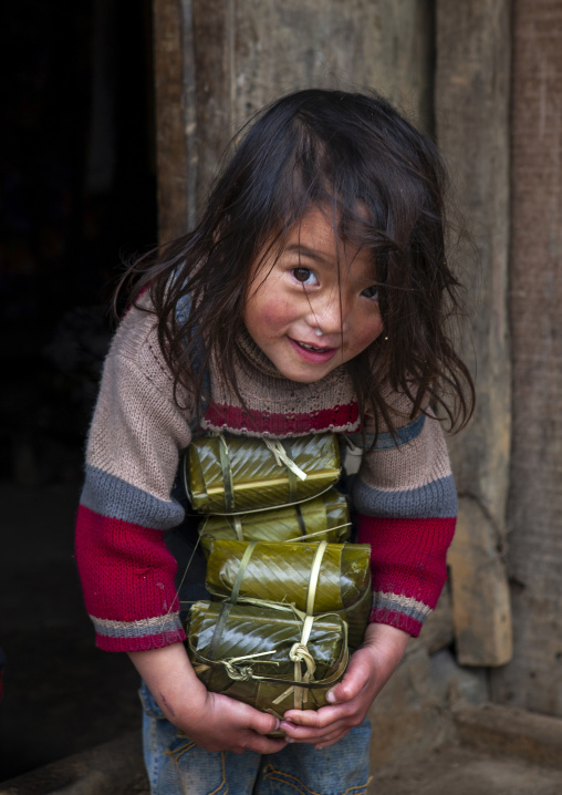 Black Hmong girl holding wrapped rice cakes for tet, Lao Cai province, Sapa, Vietnam