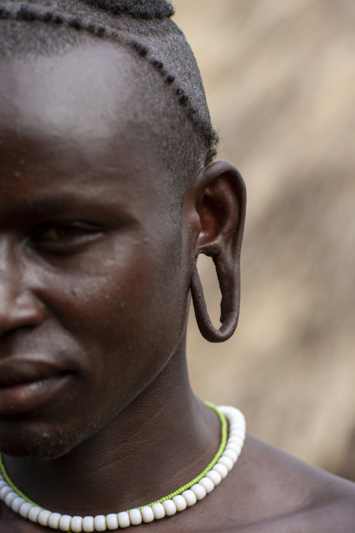 Portrait of a surma tribe man with enlarged ear, Omo valley, Tulgit, Ethiopia