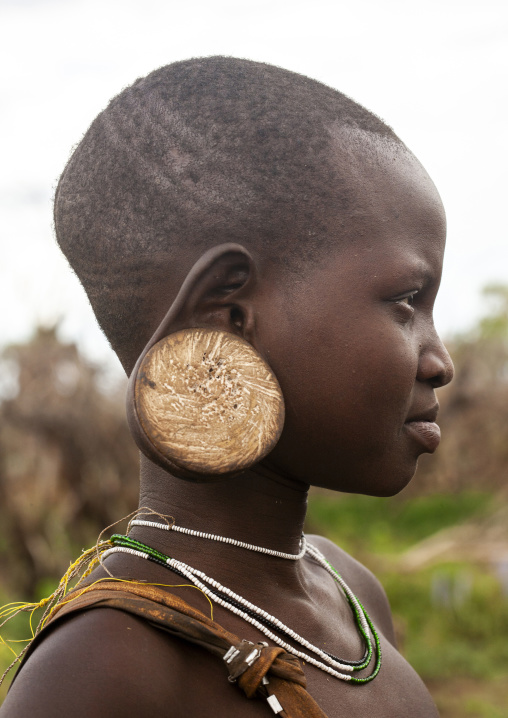 Mursi tribe young girl with enlarged ear, Omo valley, Mago National Park, Ethiopia