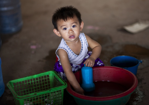 Boy playing with water in buckets, Vientiane prefecture, Vientiane, Laos