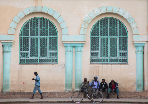 Eritrean people in front of a building from the italian colonial times near the mosque, Central region, Asmara, Eritrea