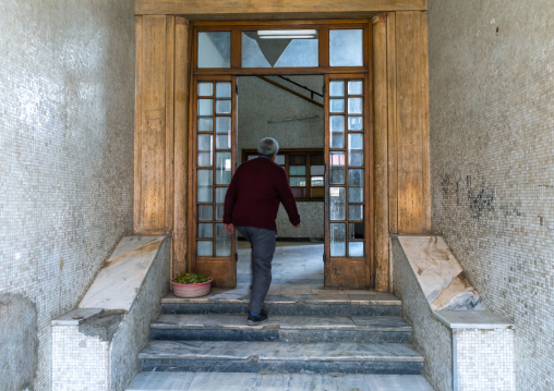 Eritrean man in an old art deco style stairs from the italian colonial times, Central region, Asmara, Eritrea
