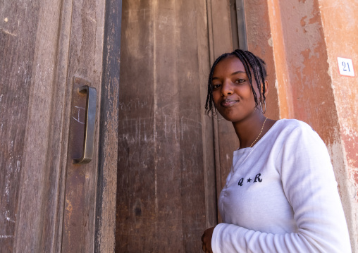 Young eritrean woman entering her house, Central region, Asmara, Eritrea