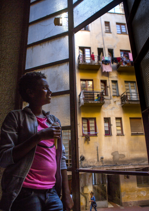 Eritrean woman standing in falletta art deco building stairs, Central Region, Asmara, Eritrea