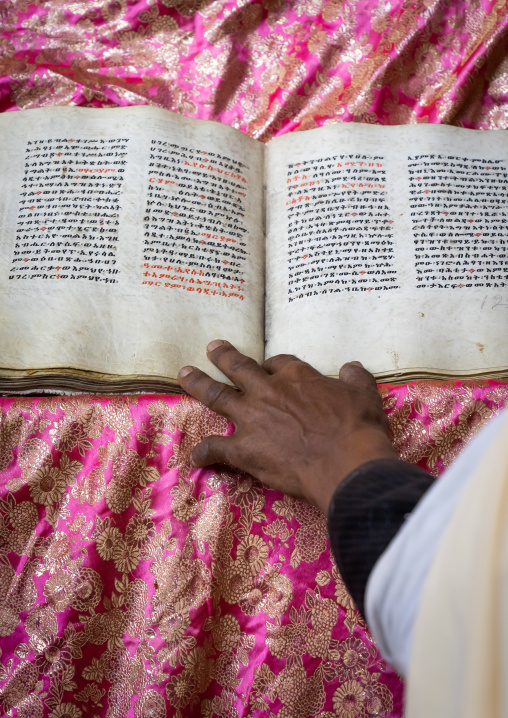 Ethiopian orthodox priest with an old bible in nakuto lab rock church, Amhara Region, Lalibela, Ethiopia