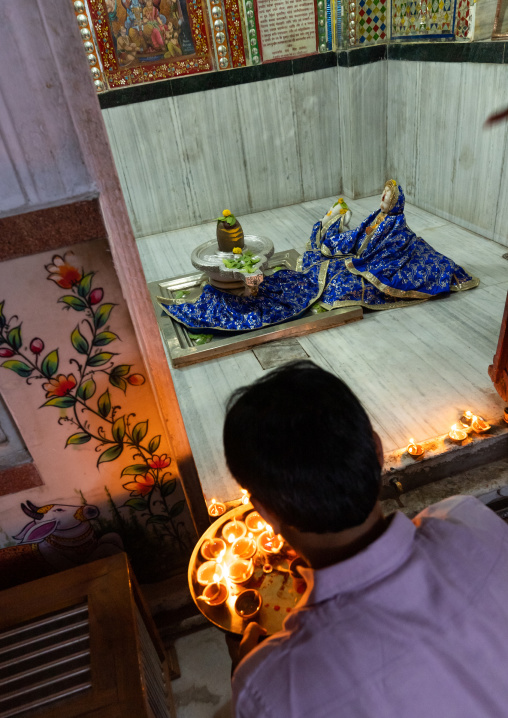 Indian man offering candles in a temple for Diwali, Rajasthan, Jaipur, India