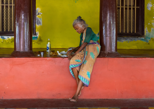 Old indian woman eating in her courtyard, Pondicherry, Puducherry, India