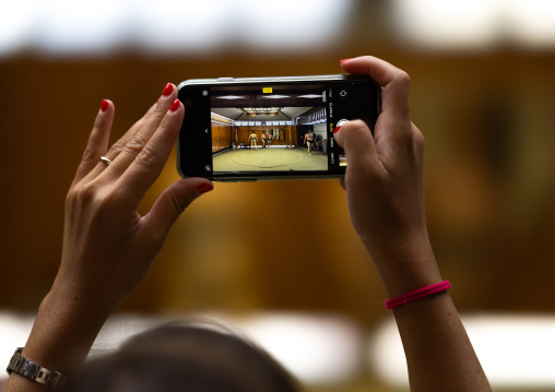 Tourist taking pictures with mobile phone in Tatsunami Beya sumo stable, Kanto region, Tokyo, Japan