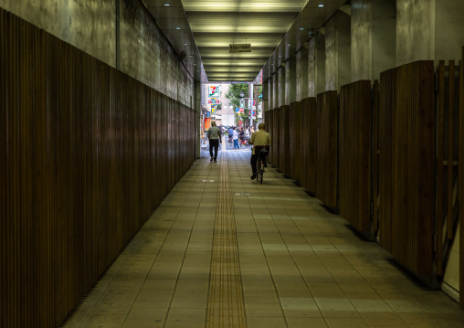 Man riding bicycle through tunnel towards the light, Kyushu region, Fukuoka, Japan