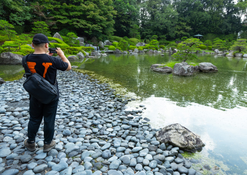 Tourist taking pictures in Ohori Park Japanese Garden, Kyushu region, Fukuoka, Japan