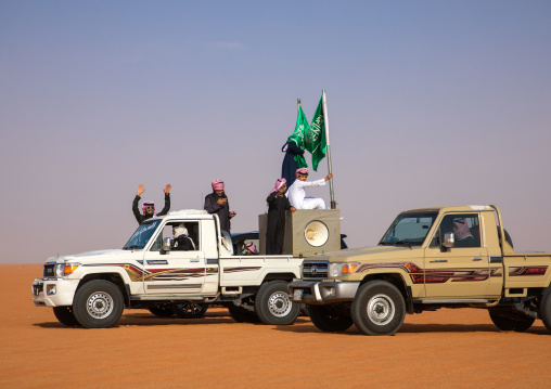 Saudi men following camels with their cars during King Abdul Aziz Camel Festival, Riyadh Province, Rimah, Saudi Arabia
