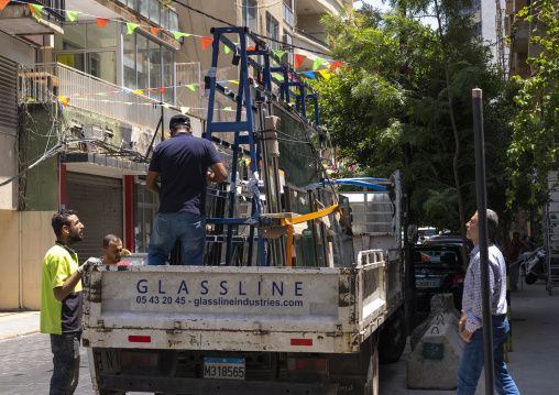 Syrian workers carrying new windows after the port explosion, Beirut Governorate, Beirut, Lebanon