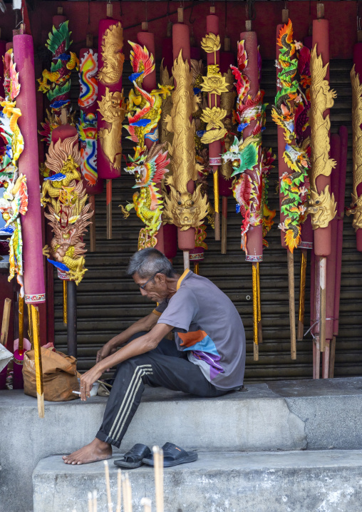 Man selling Giant dragon Incense sticks in a temple, Penang island, George Town, Malaysia