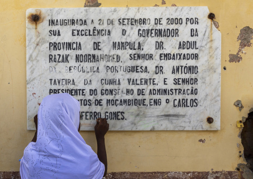 Muslim girl in front of a memorial plaque, Nampula Province, Island of Mozambique, Mozambique