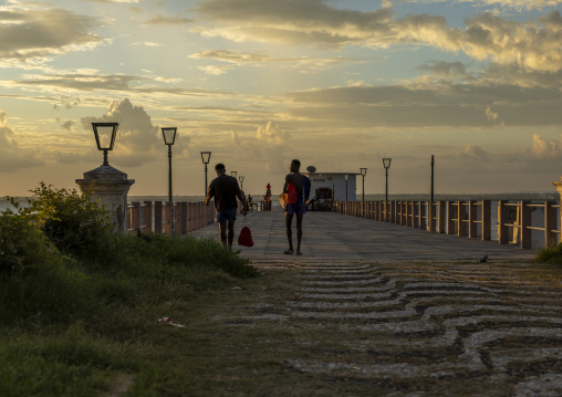 Men walking on the jetty at sunset, Nampula Province, Island of Mozambique, Mozambique