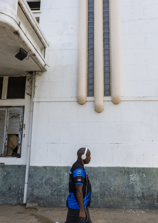 Man with headphones in front of Cine Teatro Africa, Maputo Province, Maputo, Mozambique