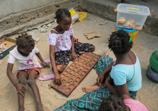 Children playing mancala with their mother, Inhambane Province, Inhambane, Mozambique