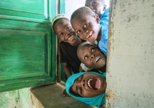 Laughing children looking throught a window in a mosque, Inhambane Province, Inhambane, Mozambique
