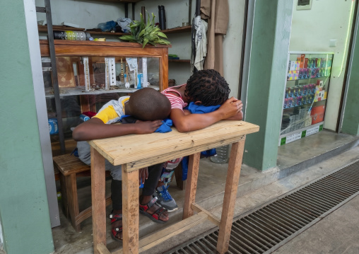 Children sleeping on a table in front of a shop, Inhambane Province, Inhambane, Mozambique