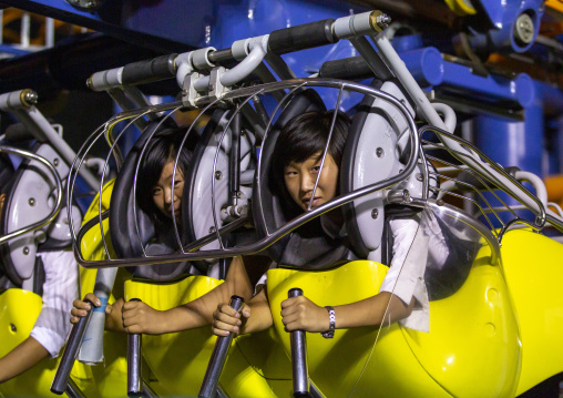 North Korean women in a fairground attraction at Kaeson youth park, DGC, Pyongyang, North Korea